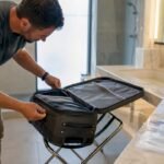 Traveler using lint roller on suitcase seams