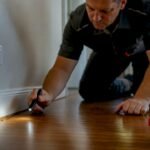 Technician inspecting ants near wall skirting