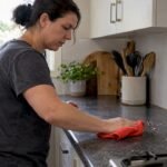 Homeowner wiping crumbs near a cockroach